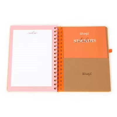 Caderno espiral aberto com páginas estampadas e bolsos de cartão