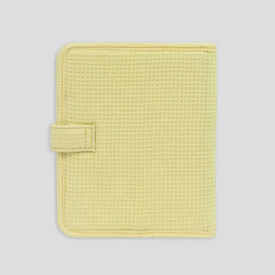 Capa quadrada amarela clara com textura de malha e fecho de aba de velcro