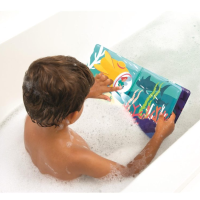 Criança a ler livro ilustrado na banheira com espuma