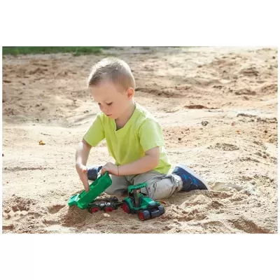 Criança a brincar com carrinho de brinquedo na areia