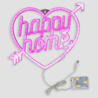 Neon rosa em forma de coração com texto 'happy home' e seta, com cabo USB e caixa de controle sobre fundo cinza.