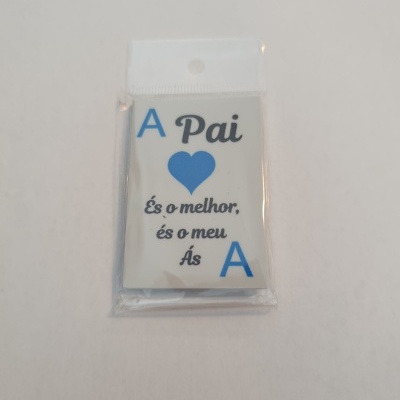 Etiqueta ou cartão branco com texto azul e preto e coração azul, embalado em plástico