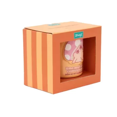Caixa laranja com caneca visível que tem desenho de cogumelo e texto em português.