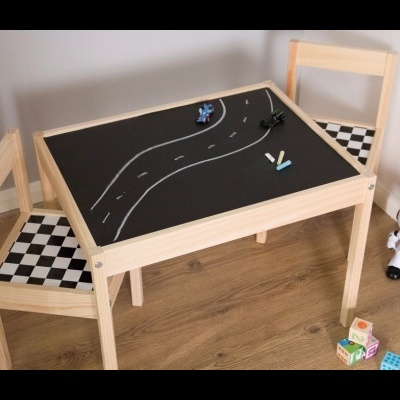 Mesa de madeira clara com tampo de ardósia e duas cadeiras com assentos xadrez preto e branco