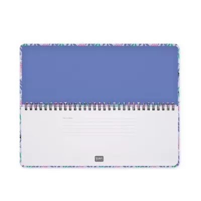 Caderno espiral com capa floral colorida aberto mostrando uma página branca com linhas de escrita e fundo azul.