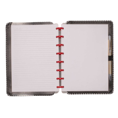 Caderno aberto com capa preta, folhas brancas, argolas vermelhas e caneta prateada na lateral direita