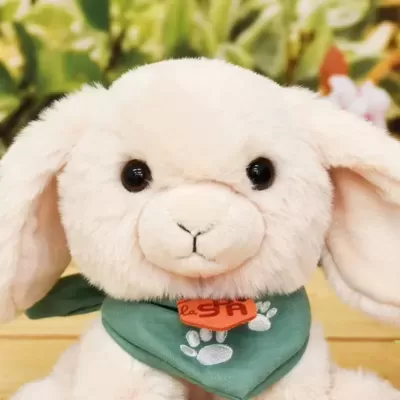 Pelúcia de coelho branca com bandana verde e etiqueta laranja
