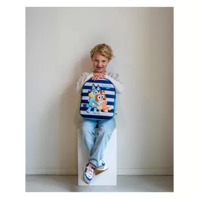 Criança segurando mochila com riscas azuis e personagens animados
