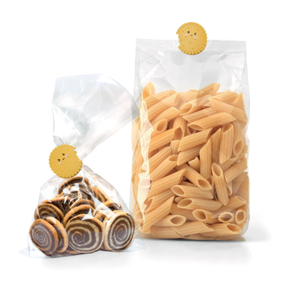 Pacotes transparentes de massa penne e biscoitos em espiral com prendedores decorativos.