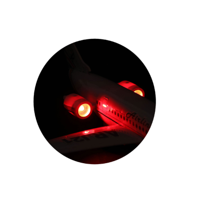 Modelo de avião com luzes vermelhas acesas em fundo negro