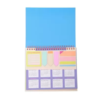 Agenda de mesa com capa azul, notas adesivas coloridas e calendário mensal.
