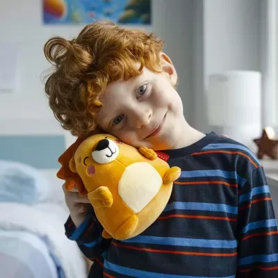 Menino loiro segurando brinquedo de pelúcia em forma de leão