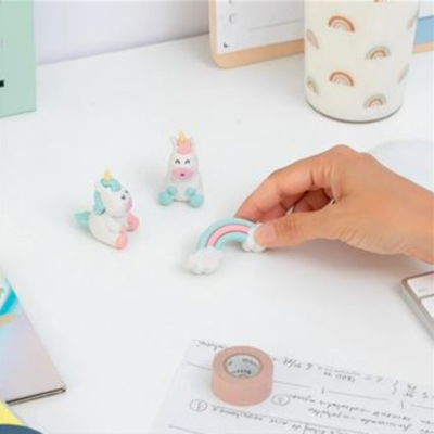 Figuras de goma de unicórnios e arco-íris numa mesa de escritório