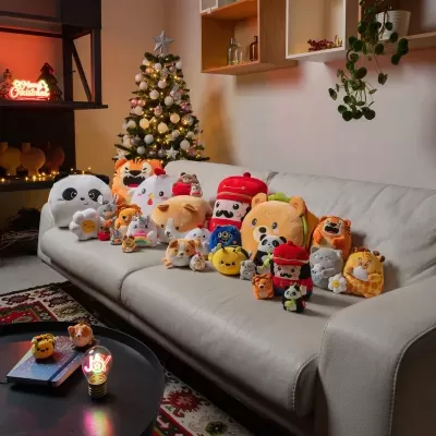 Sofá branco com peluches de animais e decoração de Natal ao fundo
