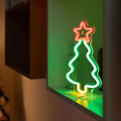 Luz de néon de árvore de Natal com estrela vermelha numa estante branca