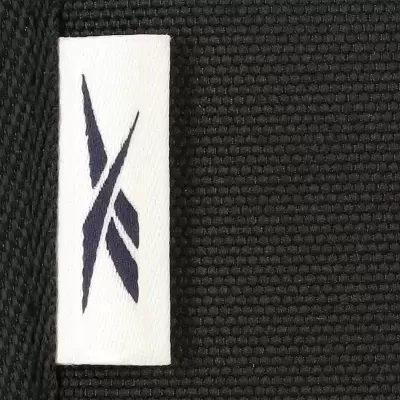 Etiqueta branca com logótipo preto em tecido preto texturizado