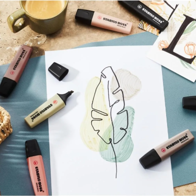 Marcadores STABILO BOSS e papel com desenho de folha sobre mesa