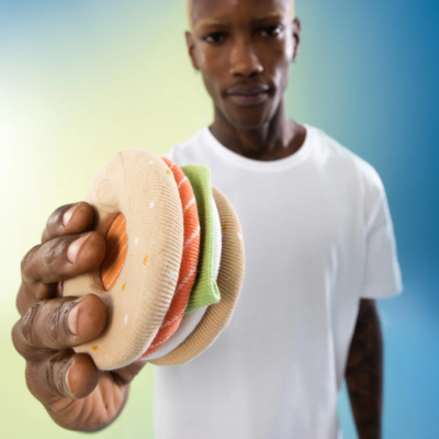 Homem a segurar hambúrguer de tecido colorido