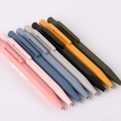 Oito canetas coloridas esferográficas alinhadas de lado