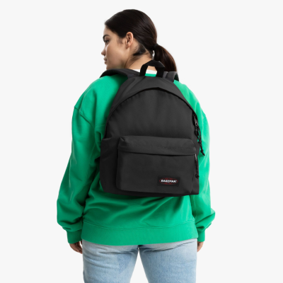 Mochila preta EASTPAK usada por pessoa com casaco verde e calças de ganga