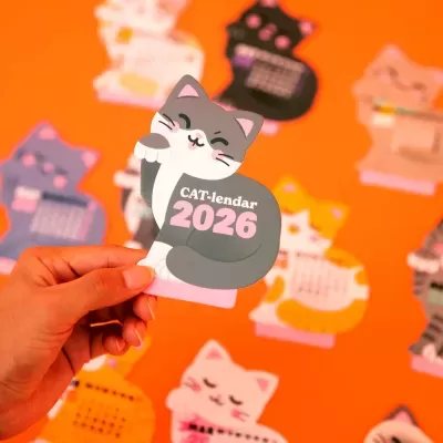 Calendário 2026 em forma de gato cinzento e branco com texto CAT-lendar 2026