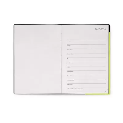 Caderno aberto com capa preta e bordas amarelas, página direita com texto para preenchimento de dados pessoais