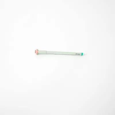 Caneta de escrita verde clara com tampa rosa sobre fundo branco