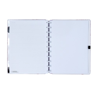Caderno prateado aberto com folhas brancas, uma pautada e outra em branco