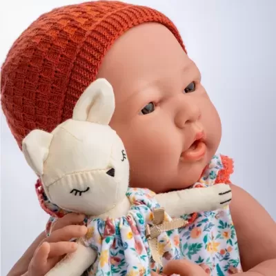 Boneca bebé realista com gorro laranja e vestido floral a segurar peluche creme