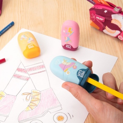 Apontadores coloridos com design divertido e ilustrações, sobre mesa com desenhos para colorir