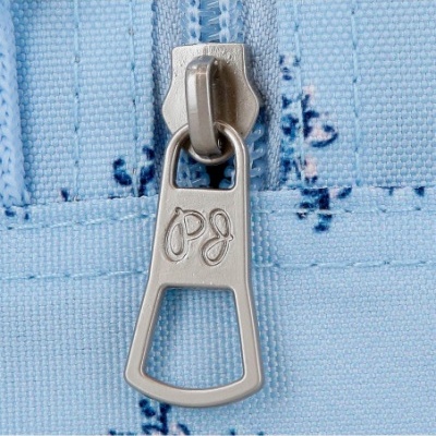 Fecho de correr metálico prateado num tecido azul claro com manchas