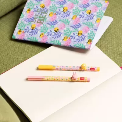 Caderno azul com abelhas e flores e dois marcadores de texto com bonecos 3D