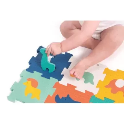 Bebé sentado a brincar num tapete de encaixe colorido com figuras de animais