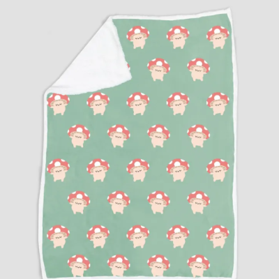 Manta verde com padrão de cogumelos vermelhos e verso branco.