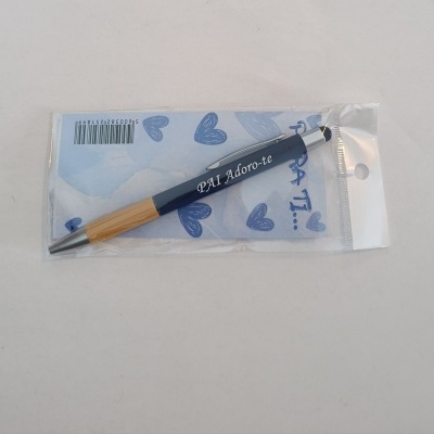Caneta azul escura com corpo em madeira clara e texto PAI Adoro-te embalada em plástico transparente com cartão azul com corações