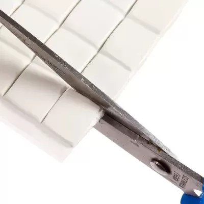 Tesoura azul a cortar barra branca segmentada