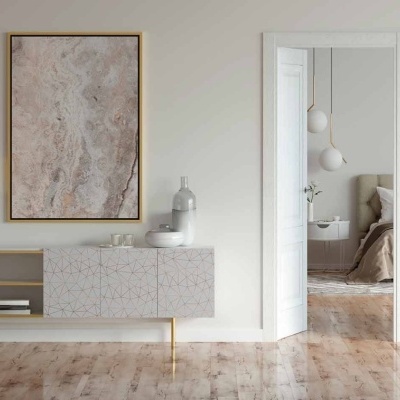 Sala minimalista com consola branca decorada, candeeiro dourado, obra de arte abstrata e vaso cinza claro