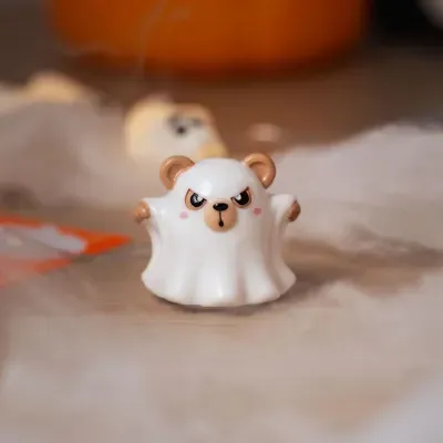 Figura de urso fantasma branco com orelhas e focinho castanhos