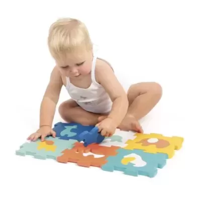 Bebé a brincar com tapete de peças de encaixar coloridas