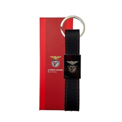 Porta-chaves preto com costura vermelha e embalagem vermelha com texto e emblema.