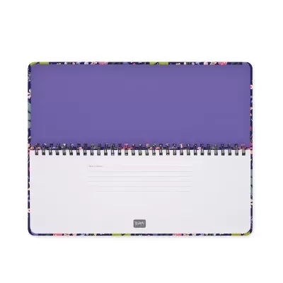 Caderno em espiral aberto com capa floral e fundo roxo