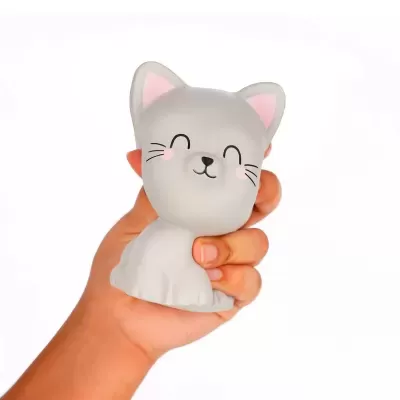 Figura de gato cinzento sorridente com orelhas cor-de-rosa segura por uma mão