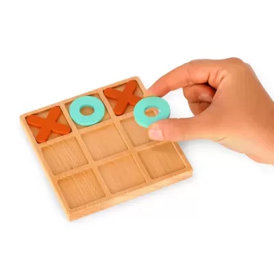 Jogo da velha madeira com peças castanho e azul-claro e mão a colocar peça O