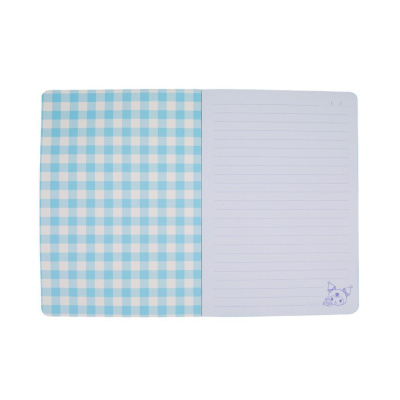 Caderno aberto com capa com padrão xadrez azul e branco e página pautada com desenho de palhaço.