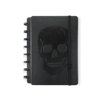 Caderno preto com caveira em relevo e argolas pretas na lateral.