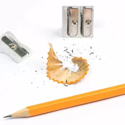 Lápis amarelo, aparas de madeira e apontadores metálicos