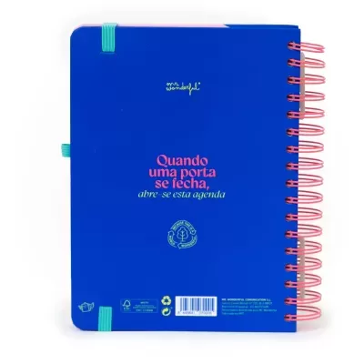 Agenda de capa azul com texto e espiral rosa