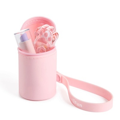 Estojo rosa com batom lilás e objeto rosado com formas arredondadas