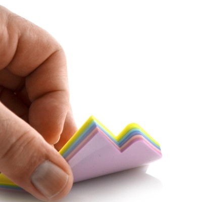 Mão a segurar post-its coloridos em forma de montanha