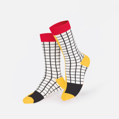 Meias brancas com padrão xadrez preto, detalhes vermelhos e amarelos.